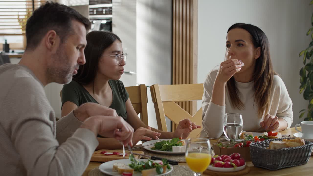 familia caucásica de tres personas compartiendo el desayuno juntos