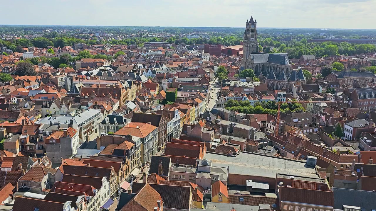 Paesaggio urbano di Bruges, Belgio, con tetti in terracotta, architettura storica, torre di chiesa gotica, strade dense del centro storico, alberi verdi e skyline panoramico per un video turistico in estate.