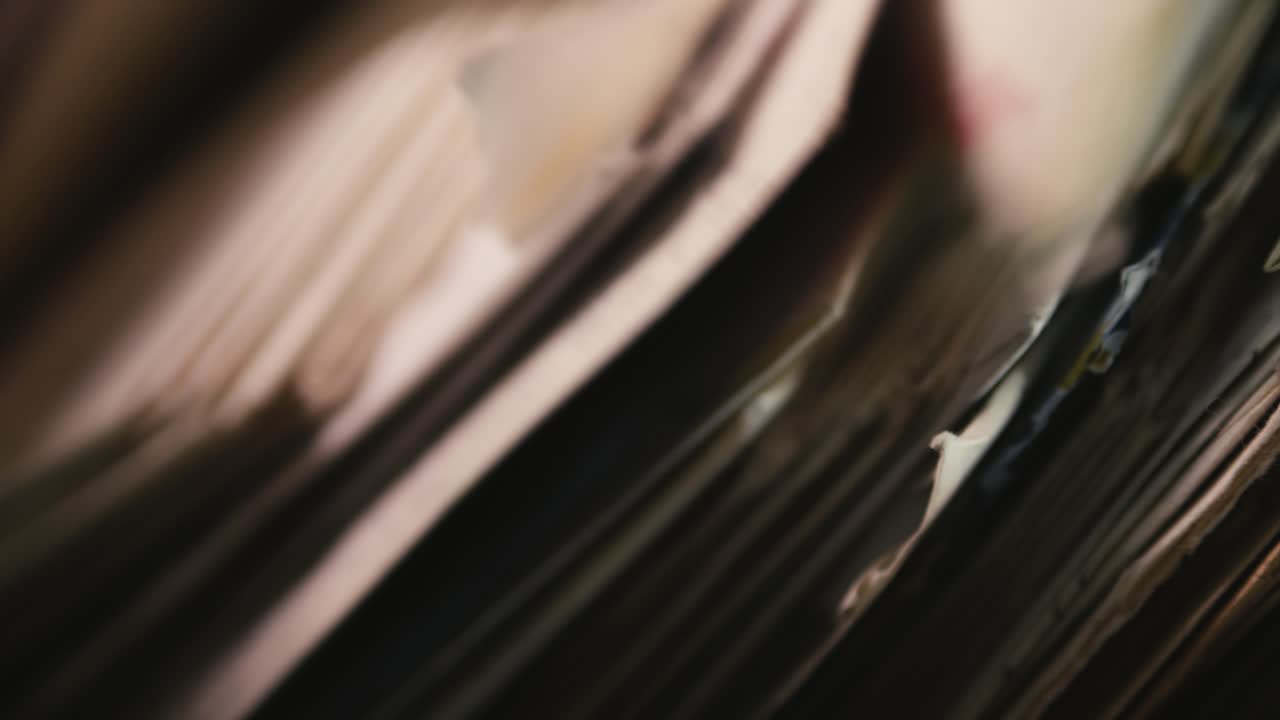 Hand searching old air mail correspondence close-up in moody shadows
