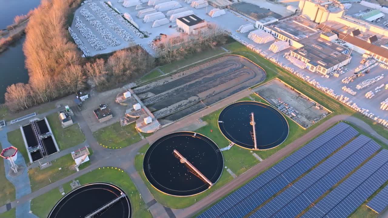 Aerial footage of a water treatment plant showcasing circular tanks and solar panels