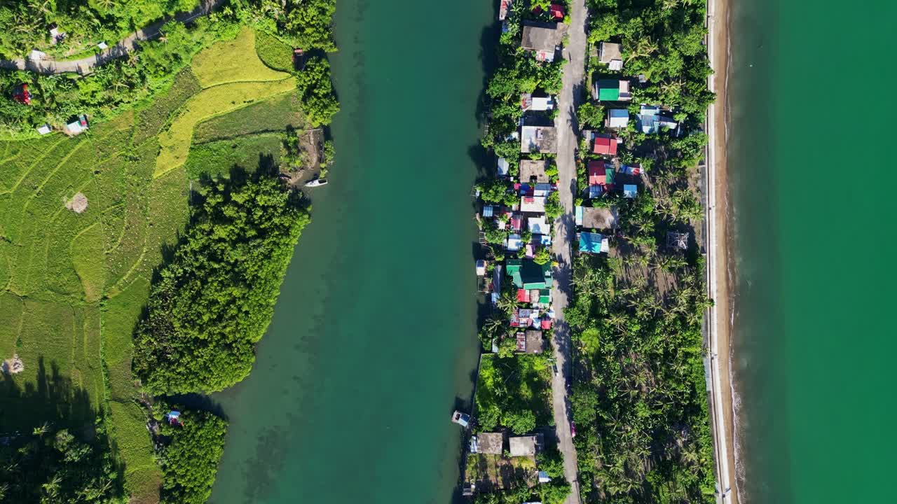 Aerial top-down view of a tropical island barangay village amid coastal ocean waters and lush mangrove river at Batalay, Catanduanes, Philippines