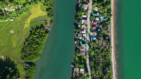 aerial top-down view of a tropical island barangay village amid coastal ocean waters and lush mangrove river at batalay, catanduanes, philippines