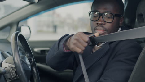 man putting on seatbelt in a car