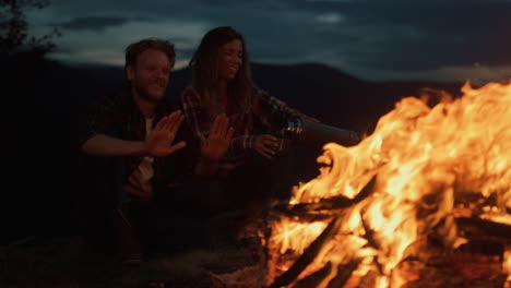 lovely campers relax bonfire in night mountains. family feel happy in nature.