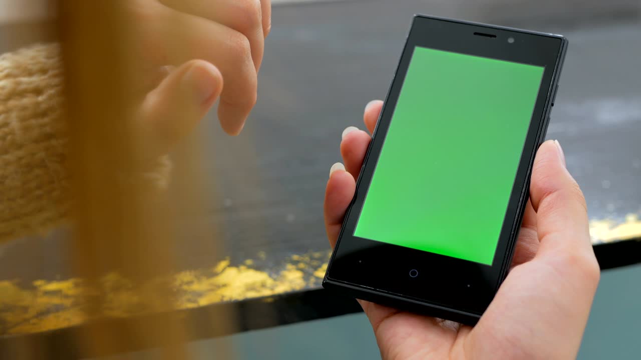 Donna che usa uno smartphone con schermo verde