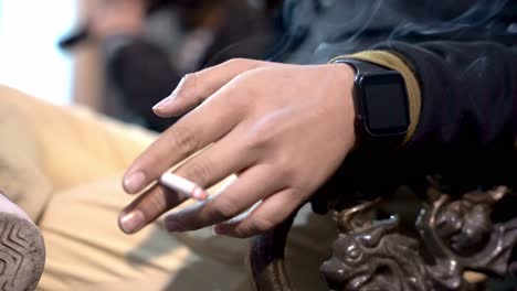 persona fumando un cigarrillo en un banco