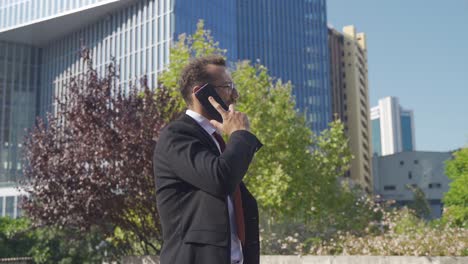 hombre de negocios caminando mientras habla por teléfono.
