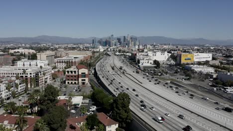 wide angle drone shot flying over highway to downtown los angeles in usa