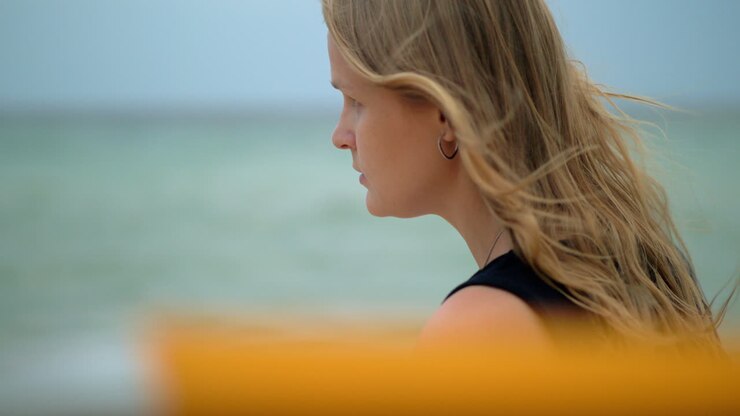 Donna con i capelli mossi dal vento. Ritratto contro il mare
