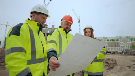Un-Grupo-De-Constructores-E-Ingenieros-Están-Inspeccionando-El-Plan-De-Construcción-De-Un-Nuevo-Objeto-En-El-Sitio-De-Construcción.