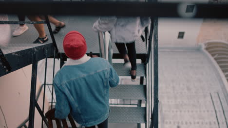 group of young multiracial friends walking up fire escape stairs ready for rooftop party chatting sharing excitement for weekend celebration