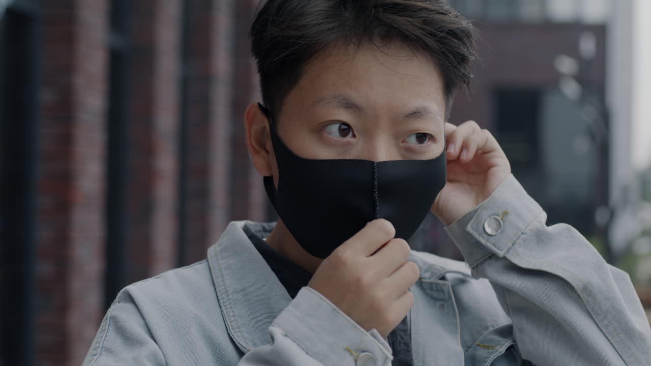 Person Adjusting Face Mask Outdoors