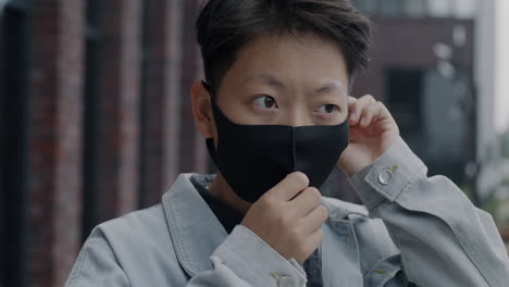 person adjusting face mask outdoors