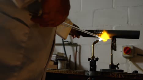 mid section of male worker blowing glass in glass factory 4k