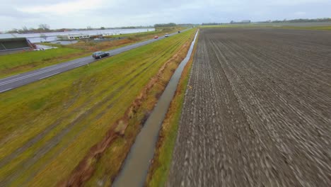 Drone-following-a-car-on-a-busy-main-road-going-through-a-rural-area