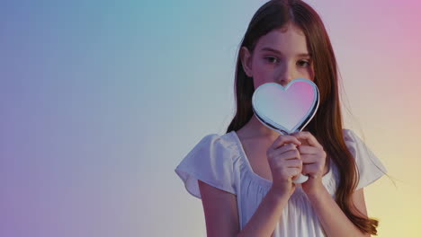 young girl holding a heart-shaped object