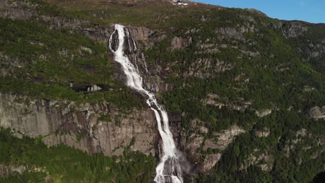 beautiful drone video of waterfall streaming from the mountains during summer