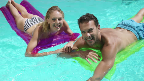 couple relaxing together in swimming pool