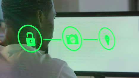 animation of network of digital icon over rear view of african american man using computer at office