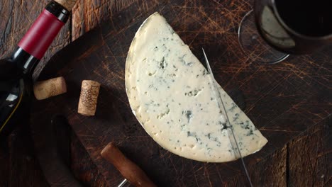 brie cheese cut off a piece on a cutting board.