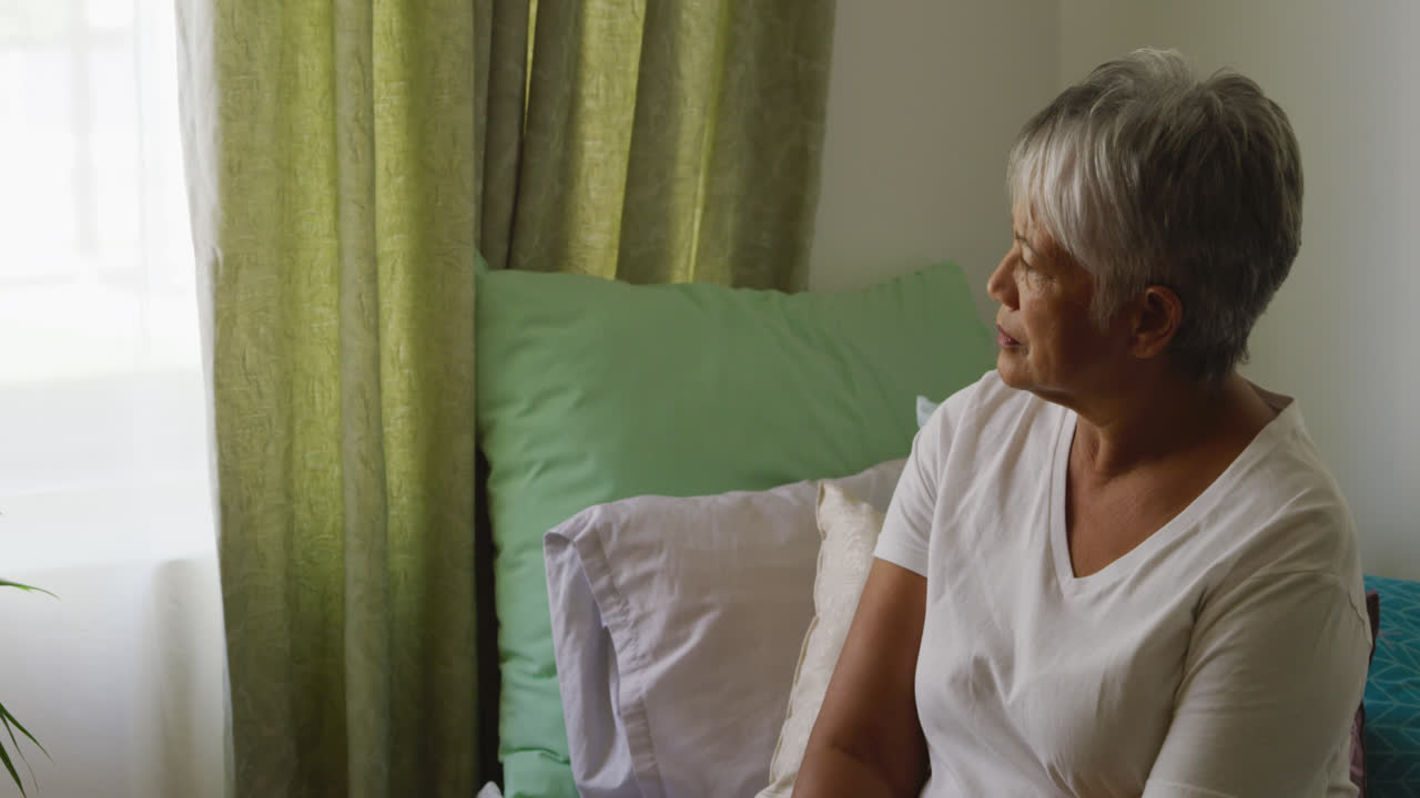 노인 가정의 방에서 사회적 거리를 지키는 고령 여성