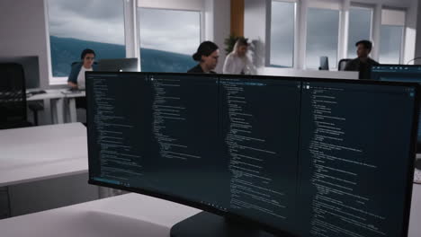 software development team working in a modern office with code on screens