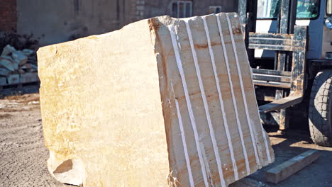 Forklift moving pallet with marble. Industrial heavy machinery forklift transporting big marble block