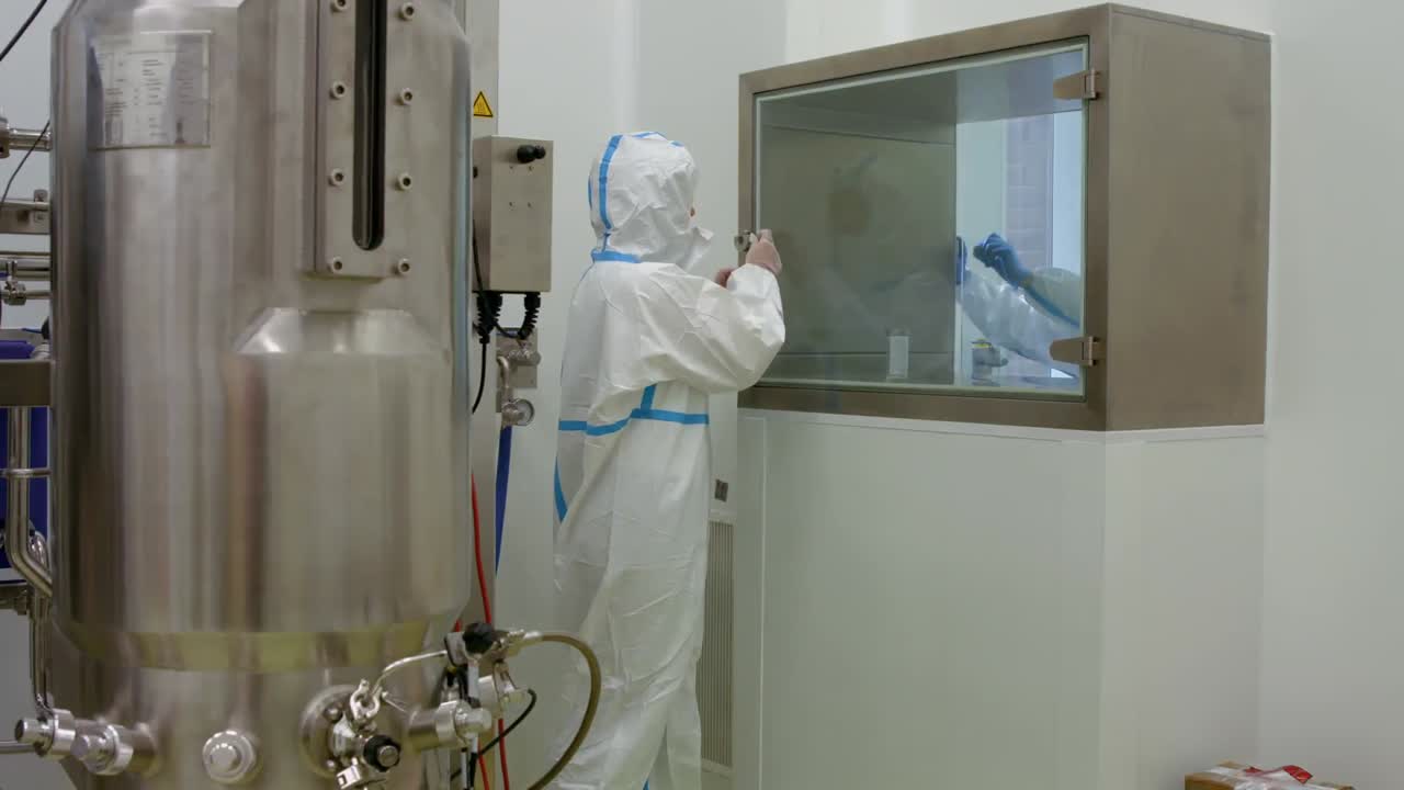 방어복을 입은 과학자가  ⁇ 크에서 일하고 있습니다.