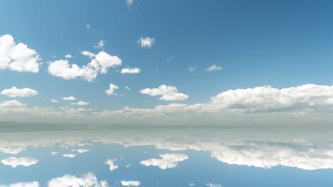 futuristic background consisting of time lapse clip of white fluffy clouds over blue sky and their reflection, video loop