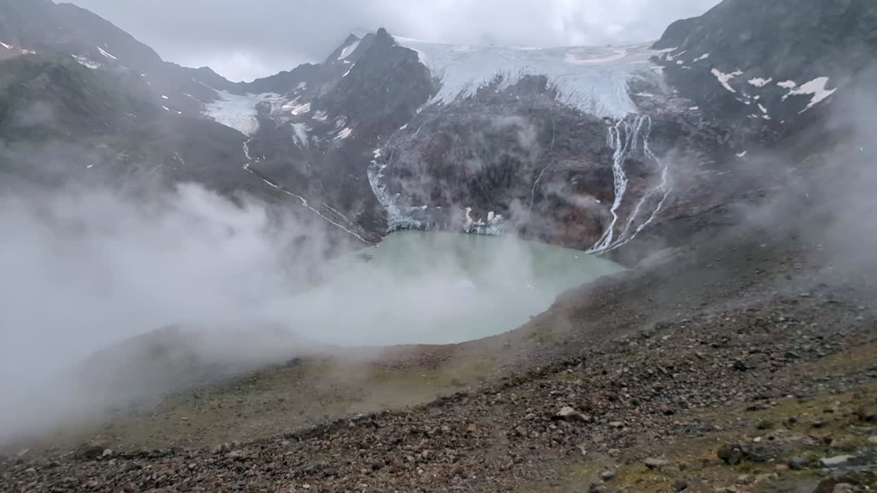 구름과 안개가 위에 거대한 빙하와 함께 원격 높은 알파인 호수 위에 굴러