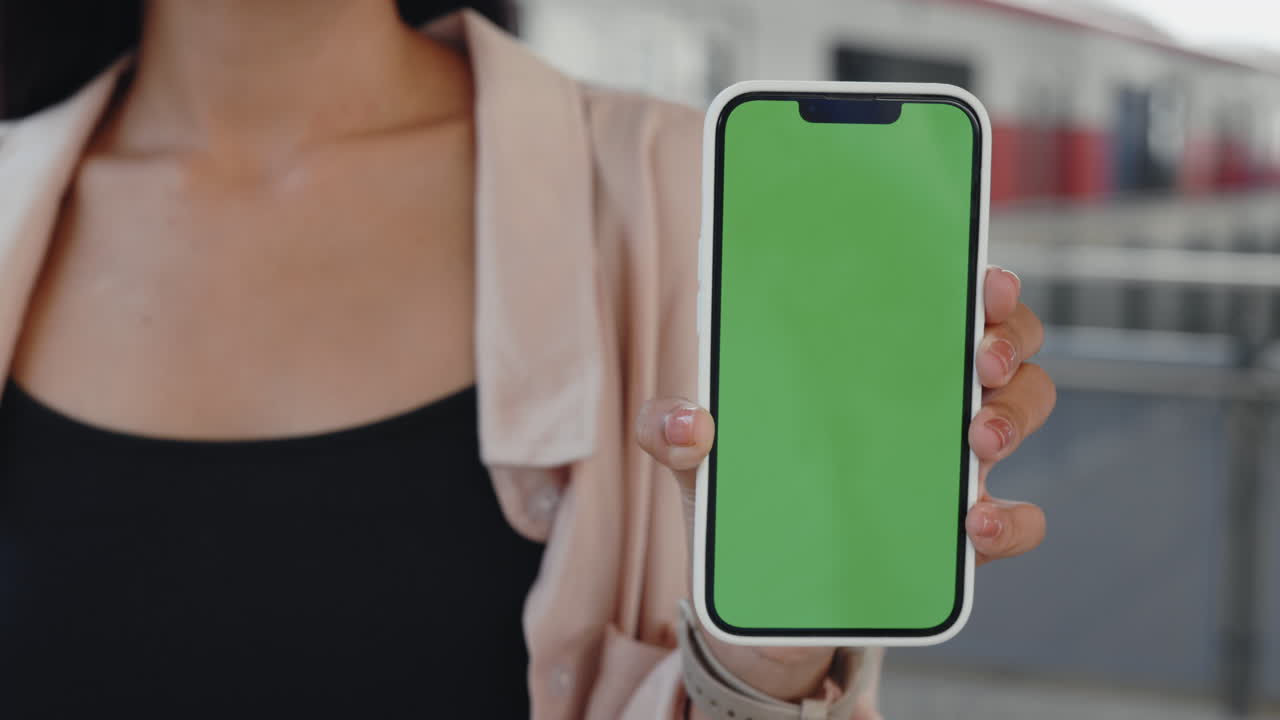 Donna che tiene smartphone con schermo verde