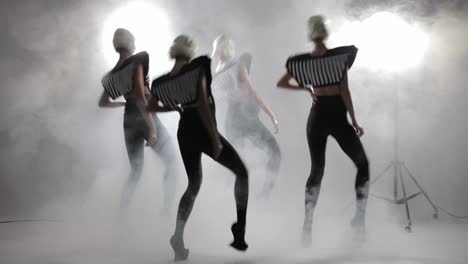 four women dancing in stylish outfits with white wigs