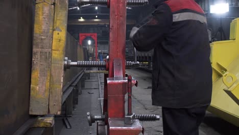 industrial worker operating machinery for assembling metal components