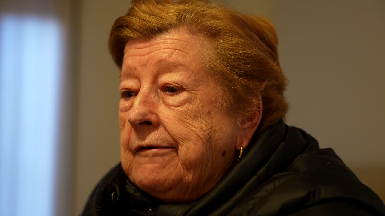 Ritratto di una donna anziana con rughe che sgranocchia uno spuntino