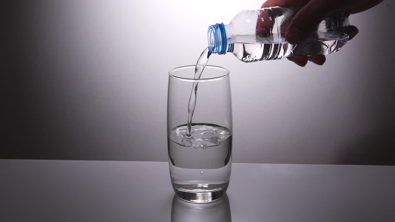 병에서 물을 유리잔에 부어 넣는 것