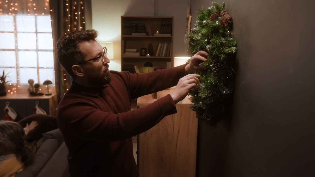 Man Decorating Christmas Wreath at Home