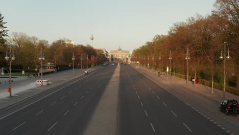 AERIAL:-Empty-Brandenburger-Tor-in-Berlin,-Germany-due-to-Coronavirus-COVID-19-Pandemic-in-Sunset-Light