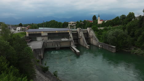 direct front view of the mavčiče hydroelectric power plant on the sava river, showcasing renewable energy infrastructure in a serene slovenian riverside.