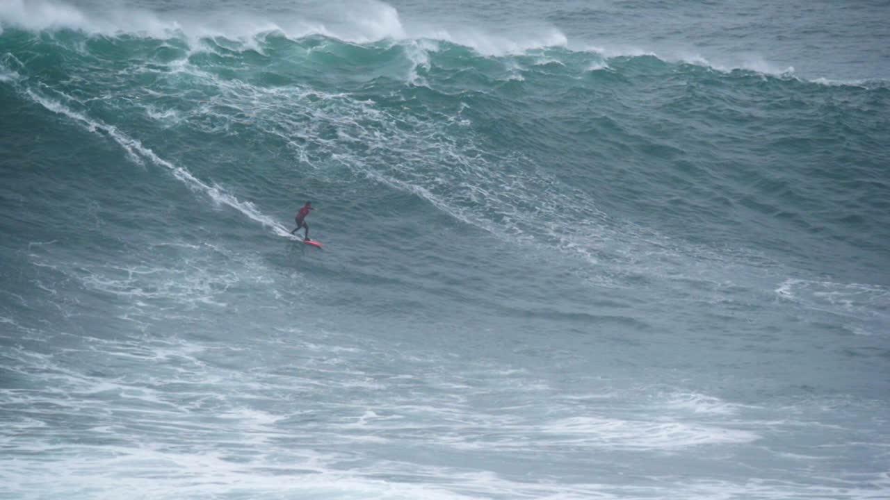 2020 cámara lenta de un surfista de grandes olas montando una ola monstruosa en nazaré, portugal