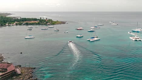 white wake trail of speedboat navigating over calm sea water in bayahibe port, la romana in dominican republic