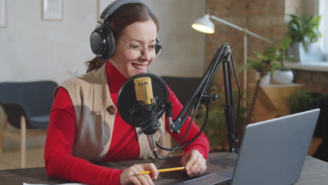 Portrait-of-Cheerful-Female-Podcaster-in-Studio