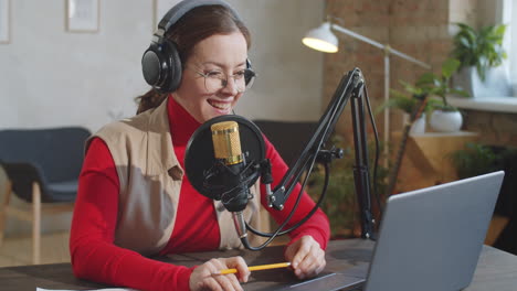 portrait of cheerful female podcaster in studio