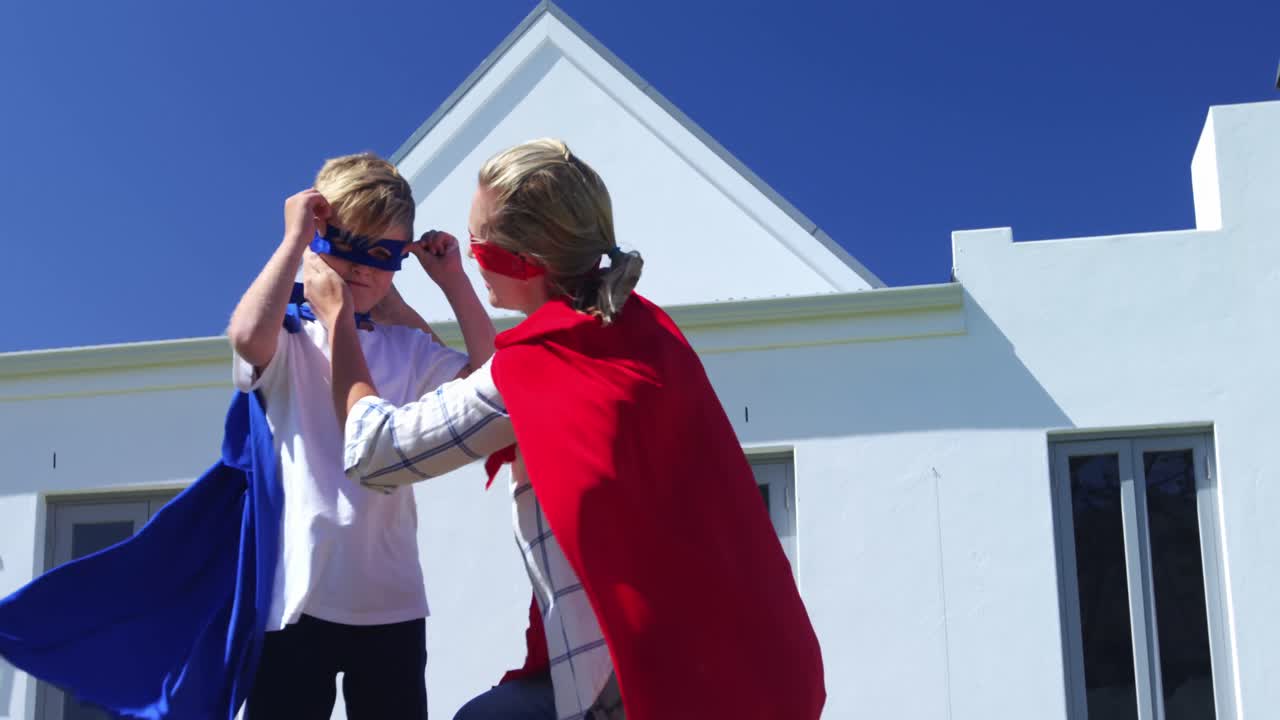 미소 짓는 엄마와 아들이 슈퍼히어로 4k인 척하고 있습니다.