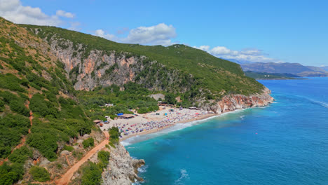 avión no tripulado hacia adelante disparado sobre la playa de arena blanca de gjipe con cañón en el fondo en albania en un día soleado