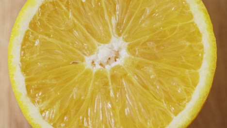 primer plano extremo de una rebanada de naranja fresca girando sobre la mesa