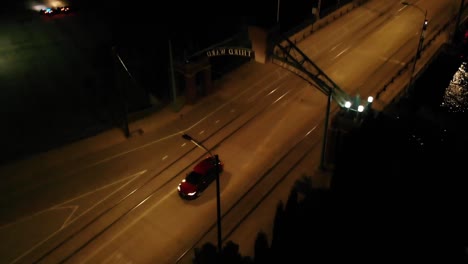 Top-Down-Panning-Shot-Of-A-Car-Crossing-A-Bridge-Then-Entering-The-City