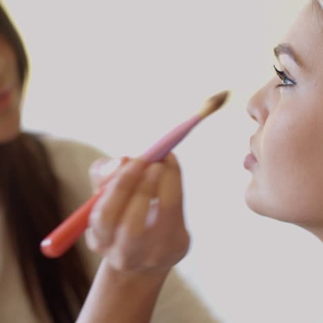 woman putting make up to her pretty friend