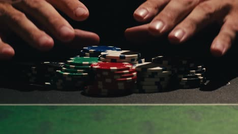 hands managing poker chips on green table, reflecting intense poker gameplay with the element of chance and skill