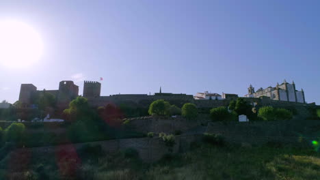 castle of monsaraz silhouette, portugueses flag waving in the wind, aerial view. alentejo