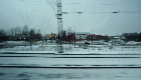 Punto-De-Vista-Desde-La-Ventana:-El-Tren-Acelera-A-Través-De-Los-Suburbios-De-La-Ciudad-En-Un-Día-Nevado-De-Invierno